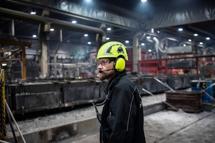 Persona usando protección auditiva con comunicación en un entorno industrial